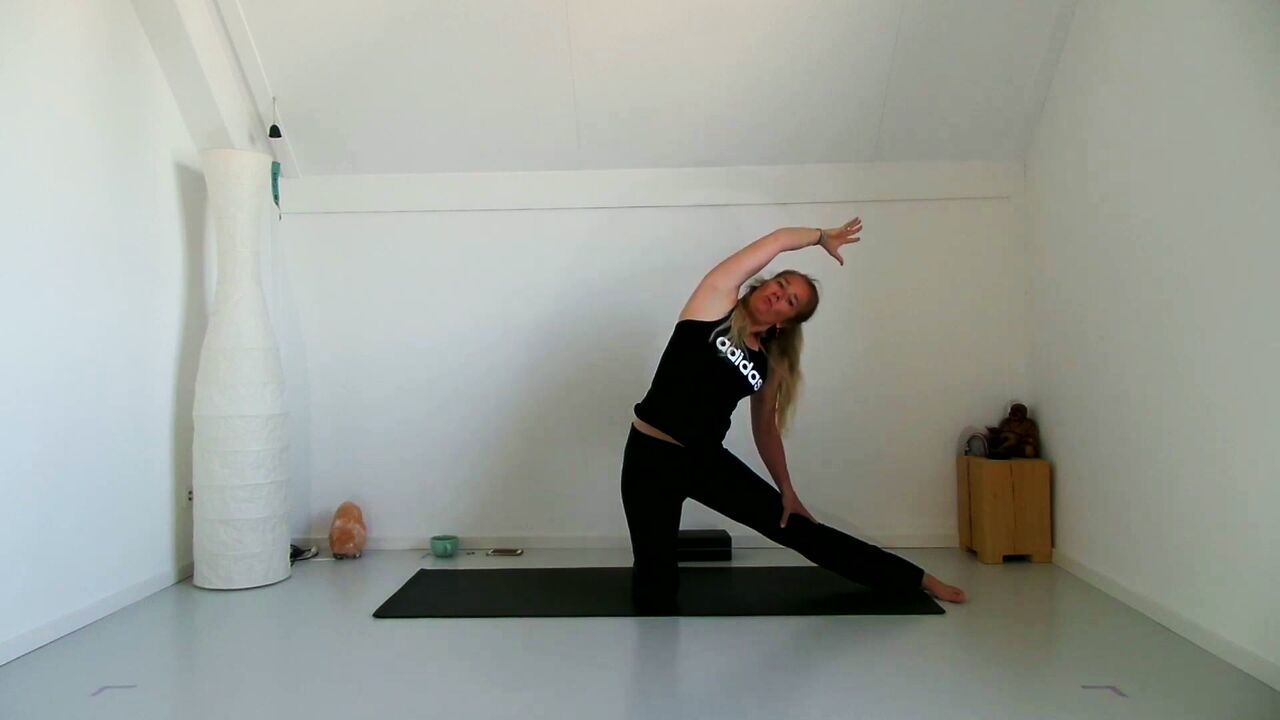 Caroline van den Ende in een zijwaartse strekking op de yogamat